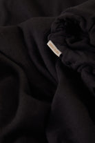 Women's Carefree Organic Garment Dye Cinch T-Shirt in the color Black - Additional Laydown image